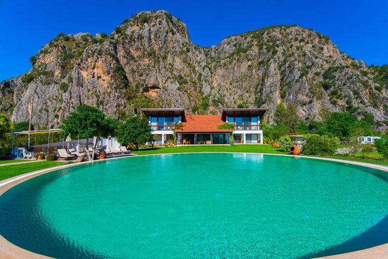 large blue pool with villa behind it